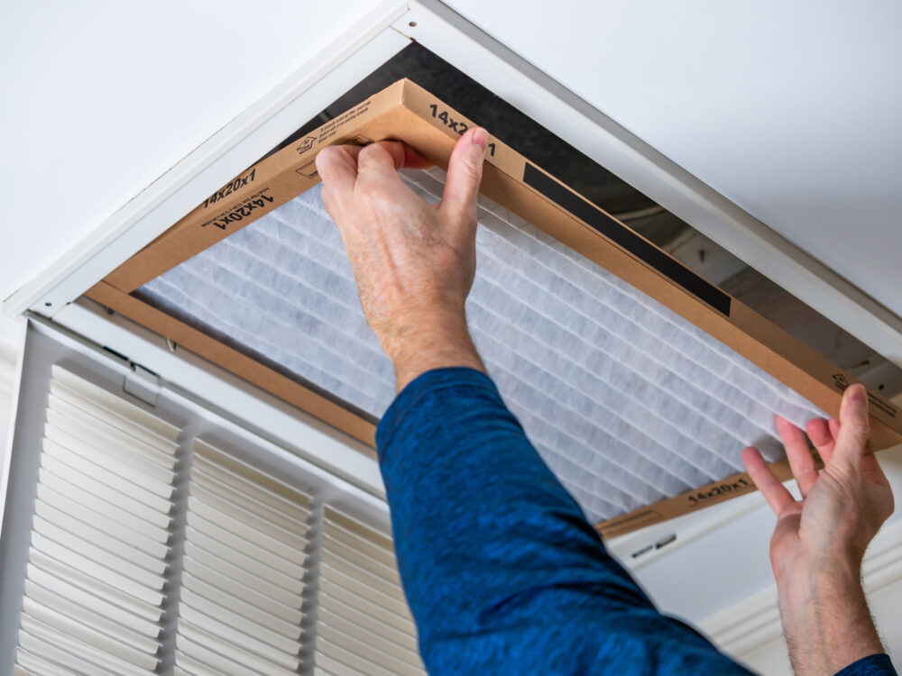 Technician installing a clean HVAC air filter