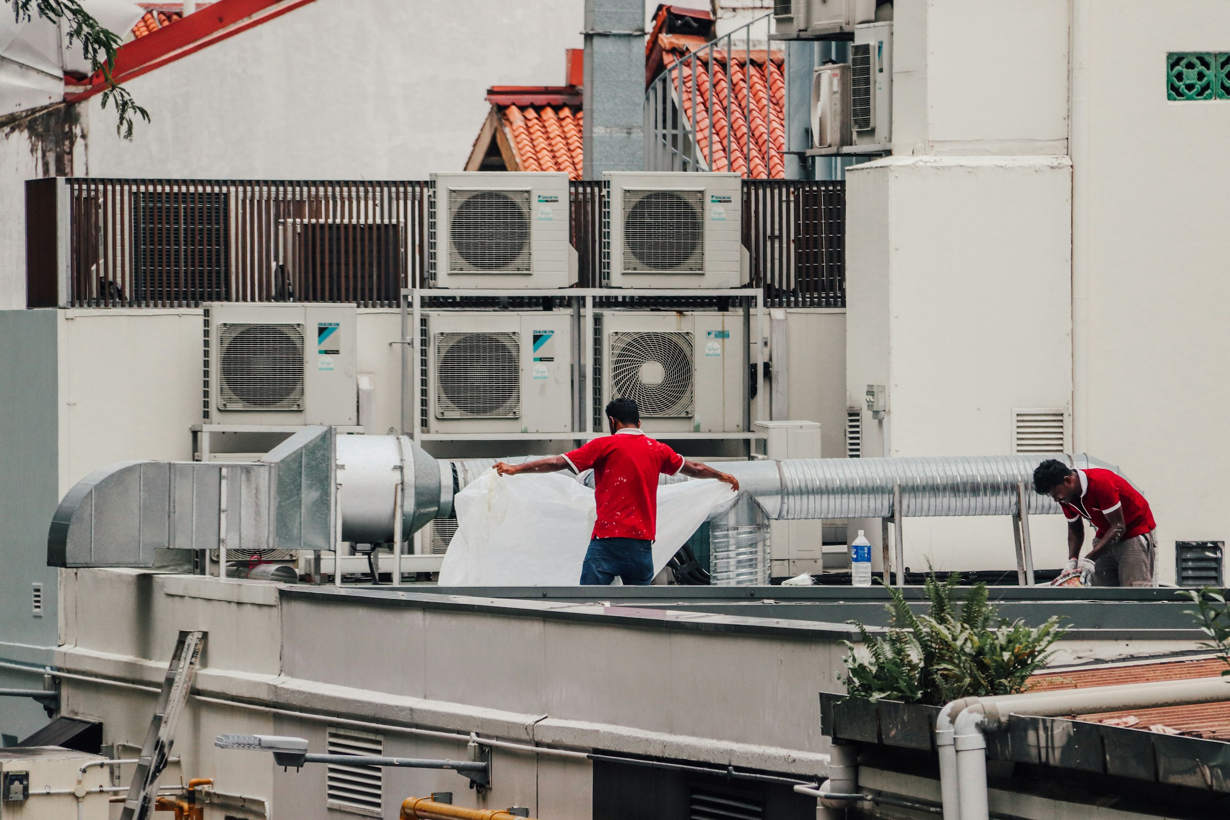 Technicians working on rooftop HVAC equipment